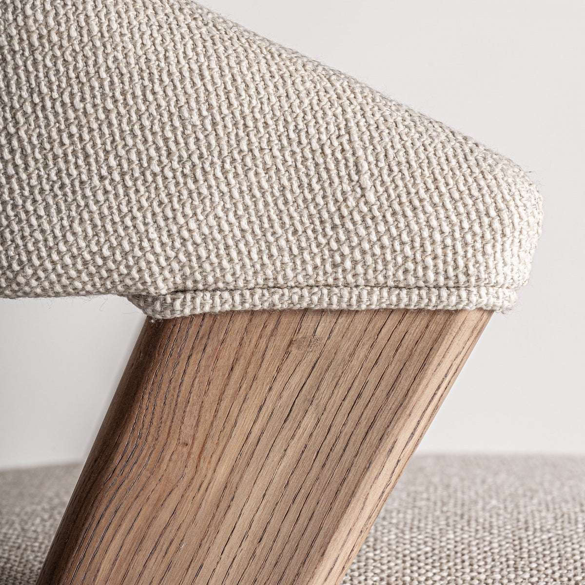 Acabado de la pata de roble y estructura inclinada en silla tapizada estilo escandinavo.