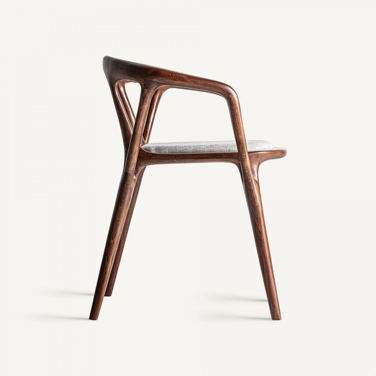 Silla vista lateral con respaldo envolvente y estructura orgánica en madera clara
