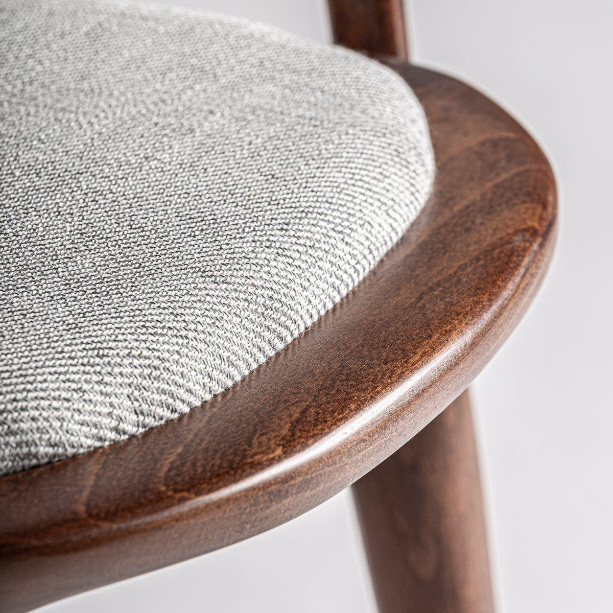 Detalle del asiento tapizado en tela beige de textura suave y natural