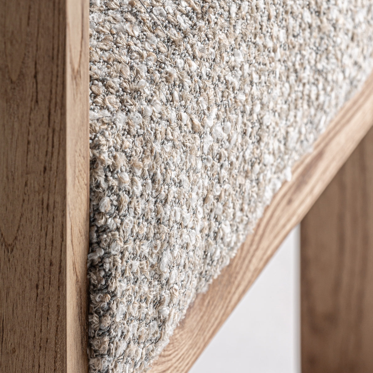 Detalle de textura bouclé en tonos naturales con acabado suave y acogedor.