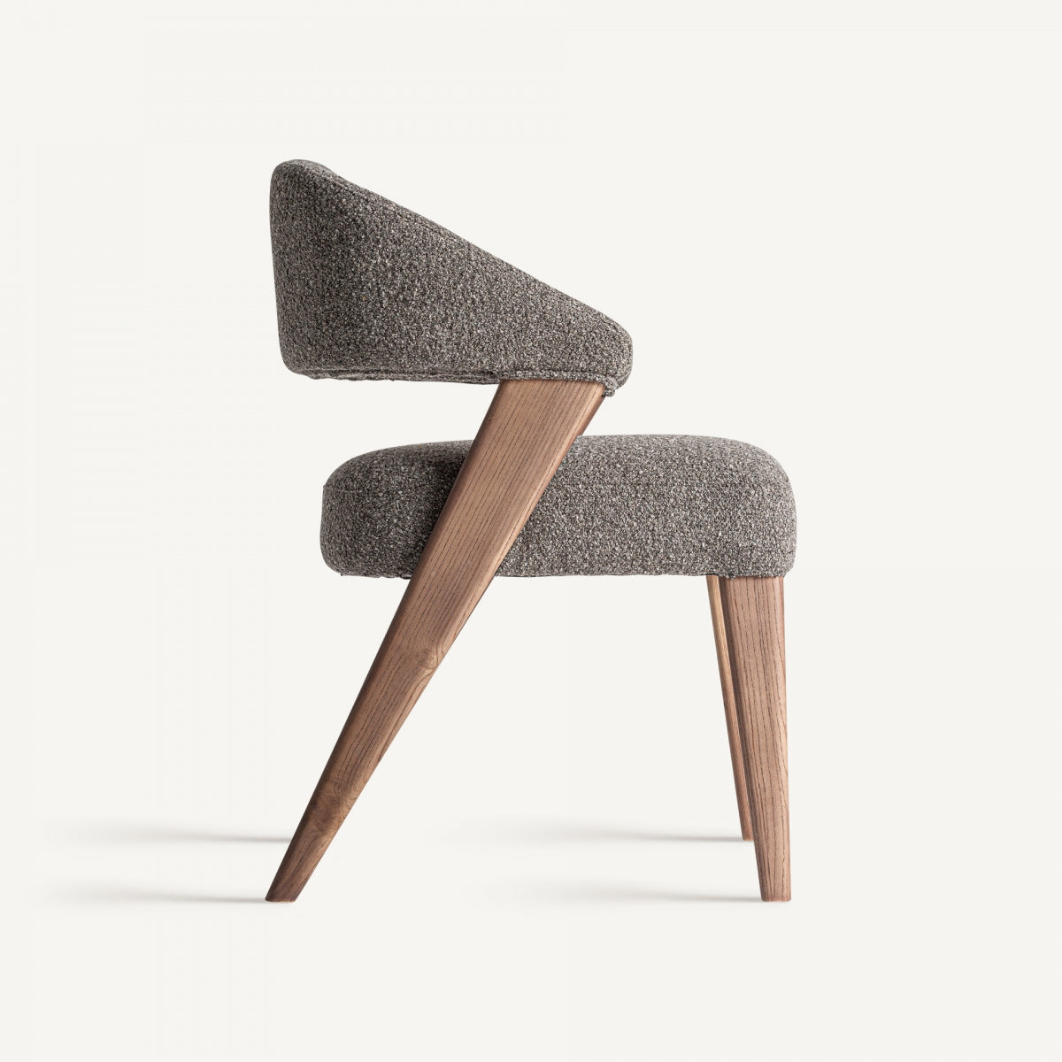Vista lateral de silla tapizada en bouclé marrón con estructura de madera inclinada