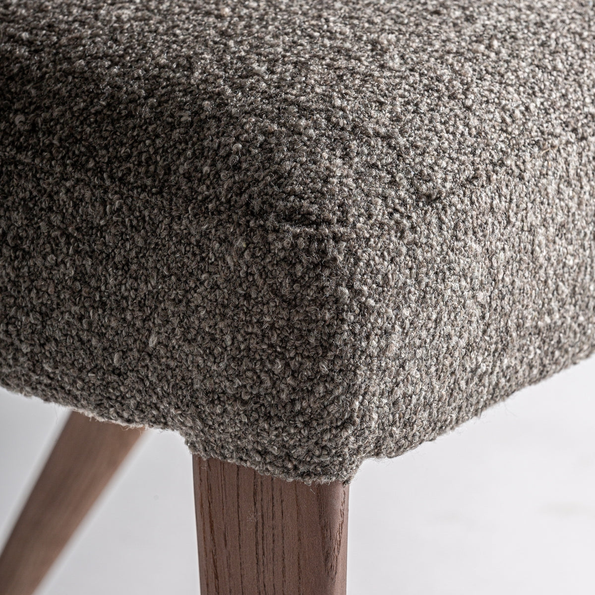 Detalle del asiento en tejido bouclé marrón con textura suave y mullida