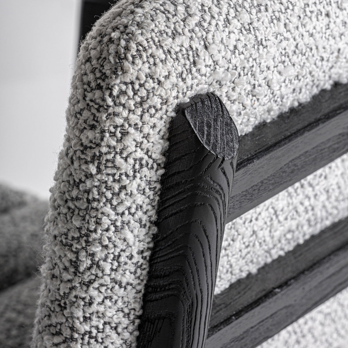 Curvatura trasera de la silla con respaldo tapizado boucle y estructura de madera negra