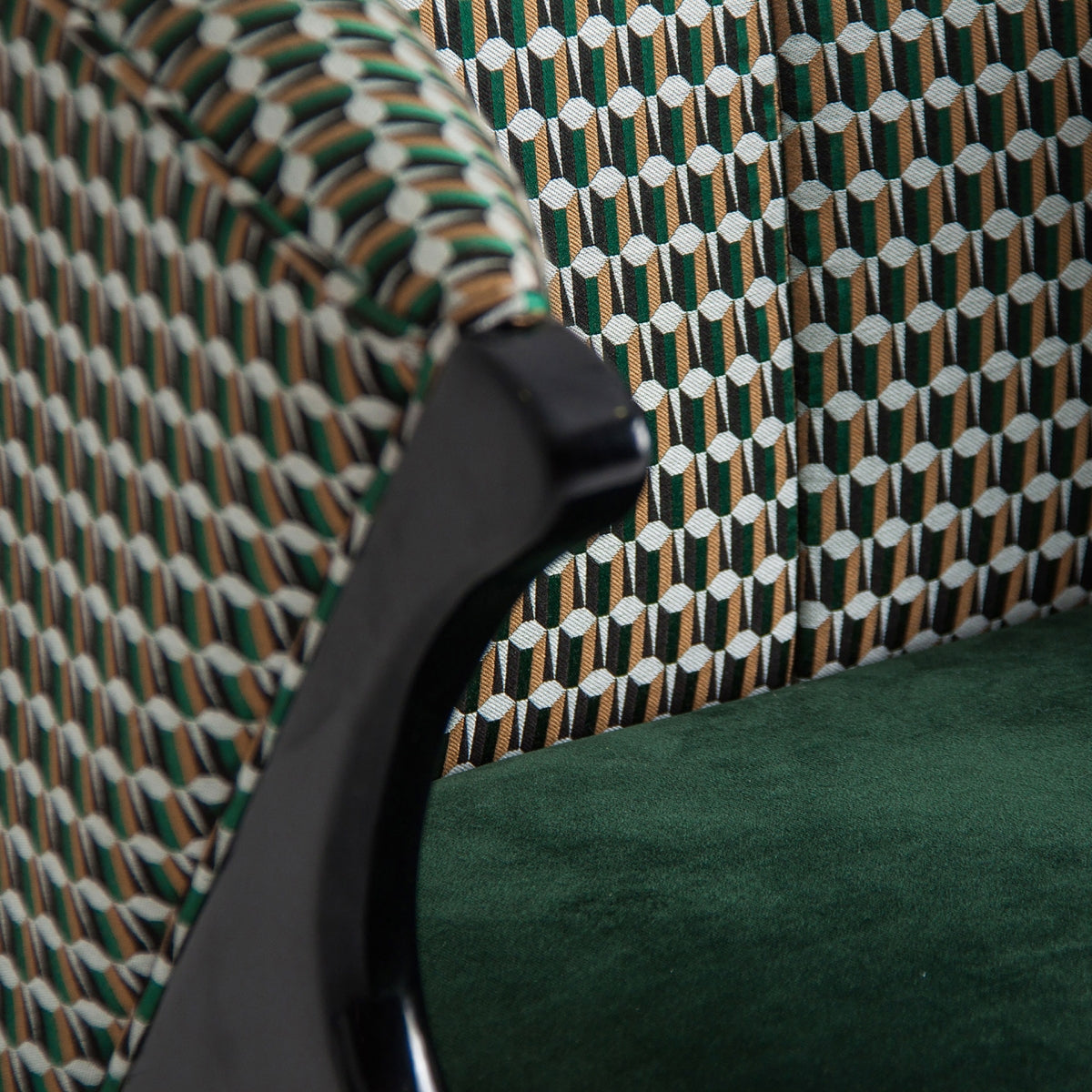 Detalle del tapizado geométrico verde y marrón en contraste con la pana verde, sofisticación textil