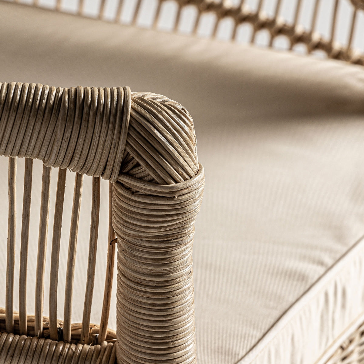 Detalle de respaldo de ratán natural trabajado a mano. Sillón Elna en ratán natural con cojín desenfundable de algodón, estilo mediterráneo cálido y ligero.