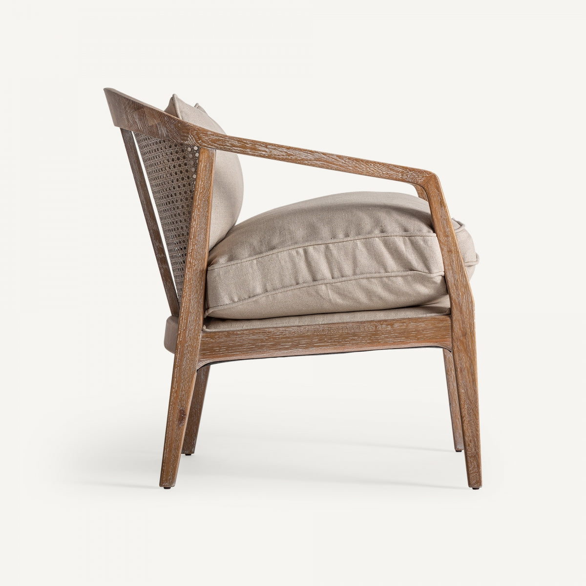 Vista lateral del sillón Gistel, estructura ligera de madera y cojines acolchados