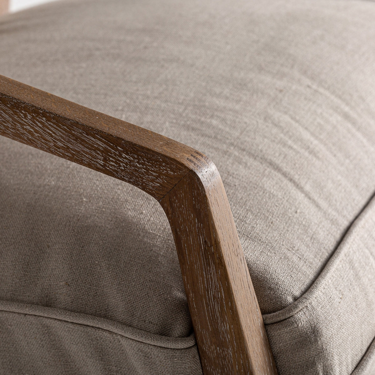 Detalle del brazo de madera del sillón Gistel, acabado en roble con veta marcada