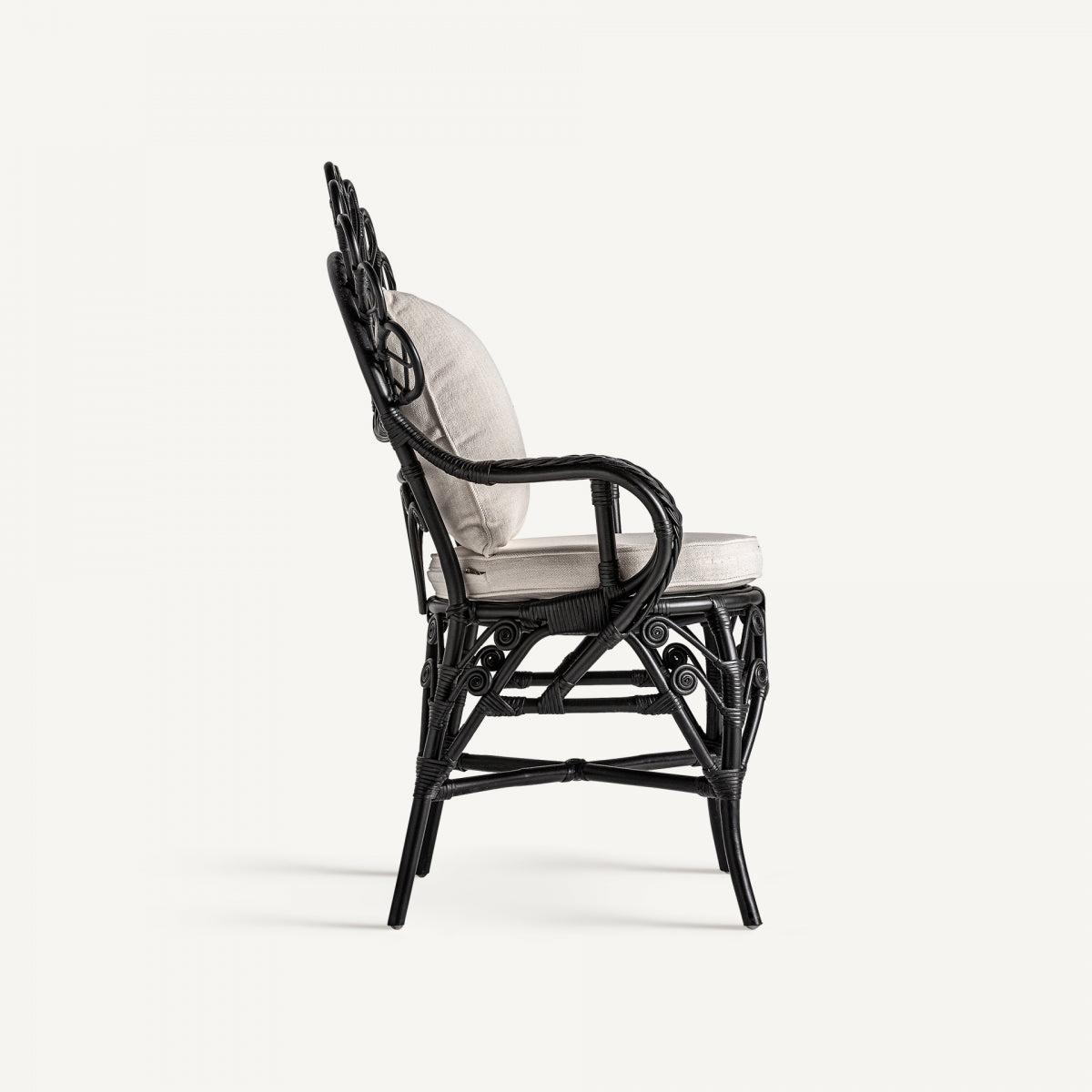 Vista lateral del sillón de ratán negro con asiento acolchado beige, ideal para espacios boho chic