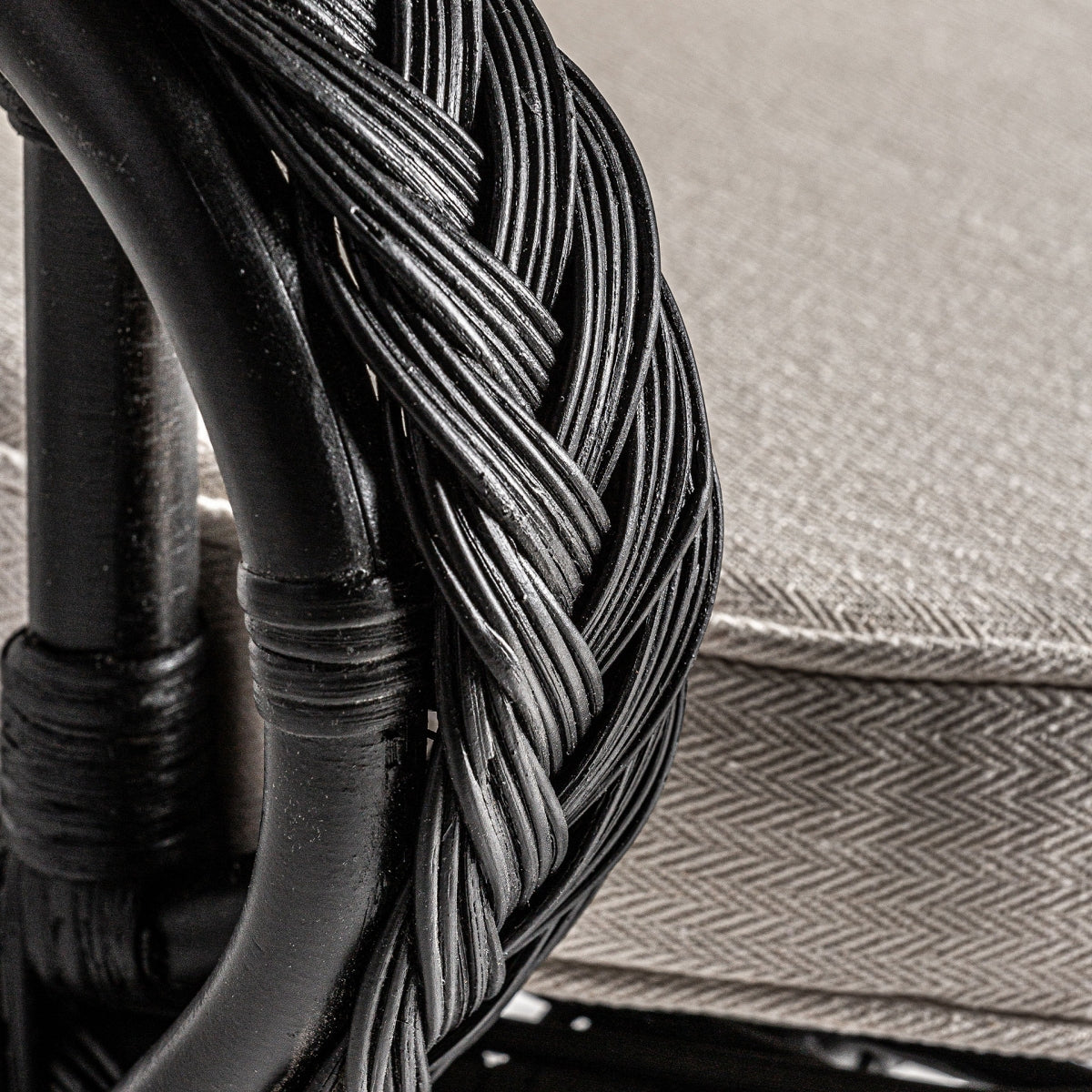 Detalle de los brazos trenzados del sillón, acabado artesanal en ratán teñido negro