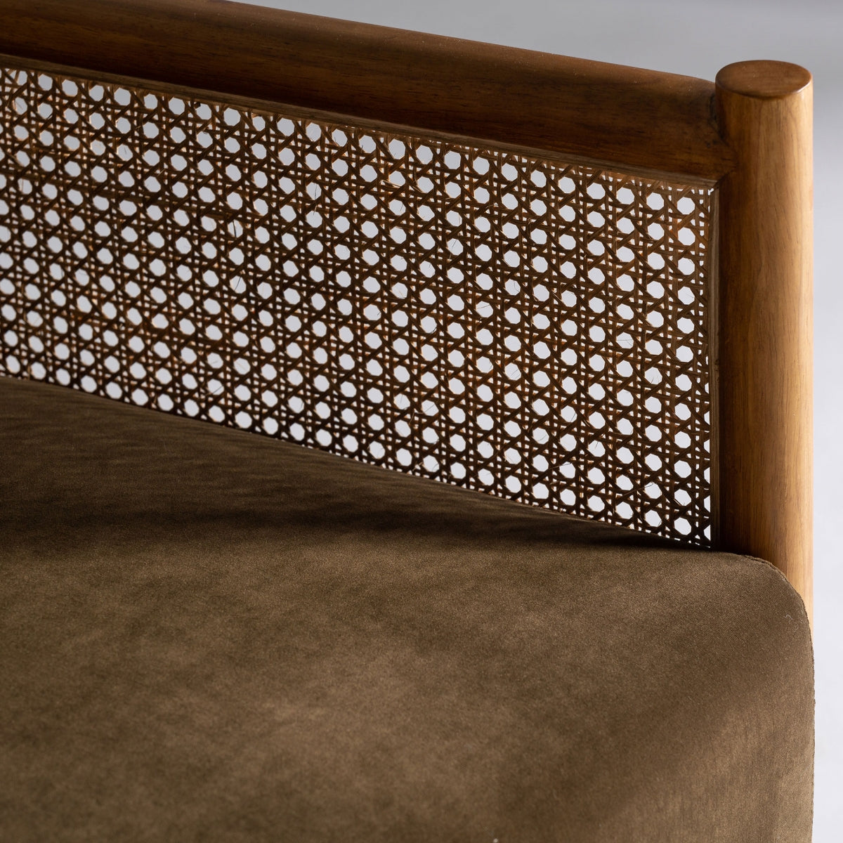 Detalle del respaldo en ratán natural entrelazado con estructura de madera. Estilo vintage con materiales nobles.