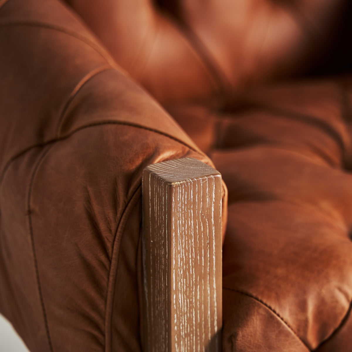 Detalle de brazo de butaca vintage con madera decapada clara y tapizado de cuero marrón, boutique interiorismo Vical