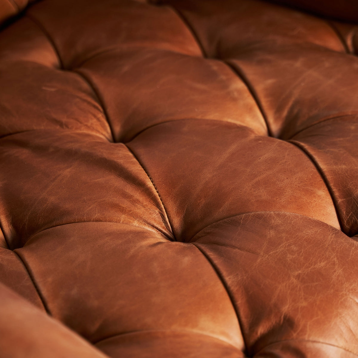 Acabado de cuero con textura natural y pespuntes capitoné en butaca de estilo vintage, boutique interiorismo Vical