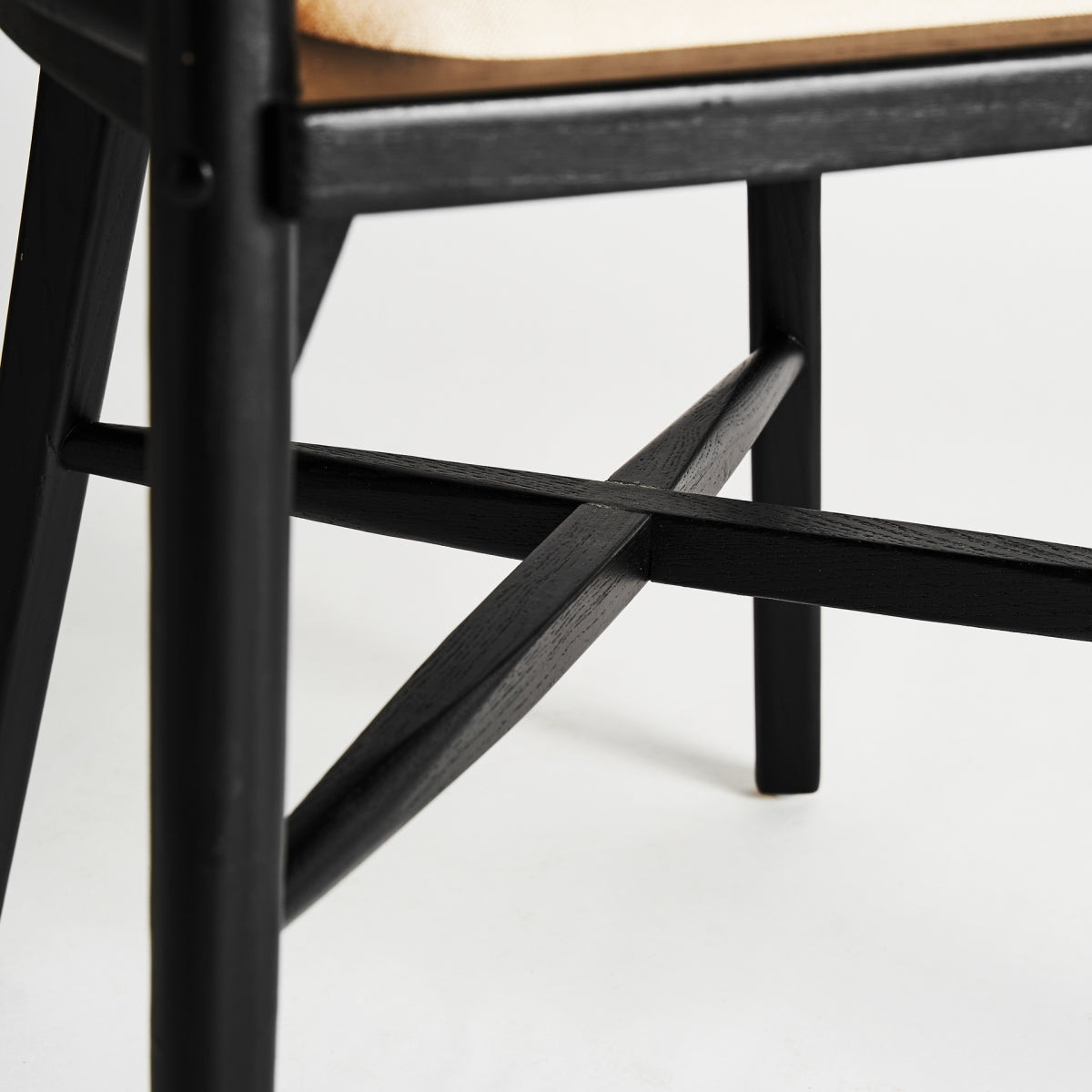 Detalle de la base cruzada del sillón en madera negra - boutique interiorismo vical