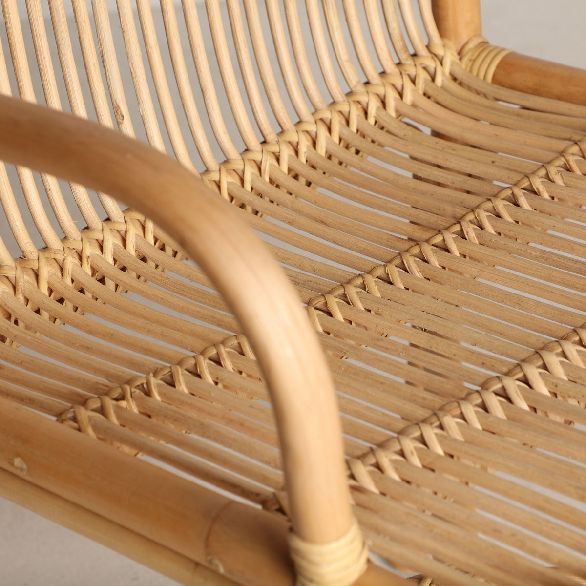 Detalle del asiento trenzado en ratán del sillón, mostrando la textura natural y la calidad artesanal del diseño.