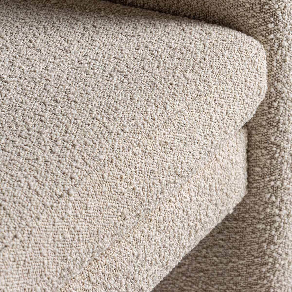 Detalle del cojín tapizado en bouclé con costuras marcadas, estilo sofisticado, boutique interiorismo Vical