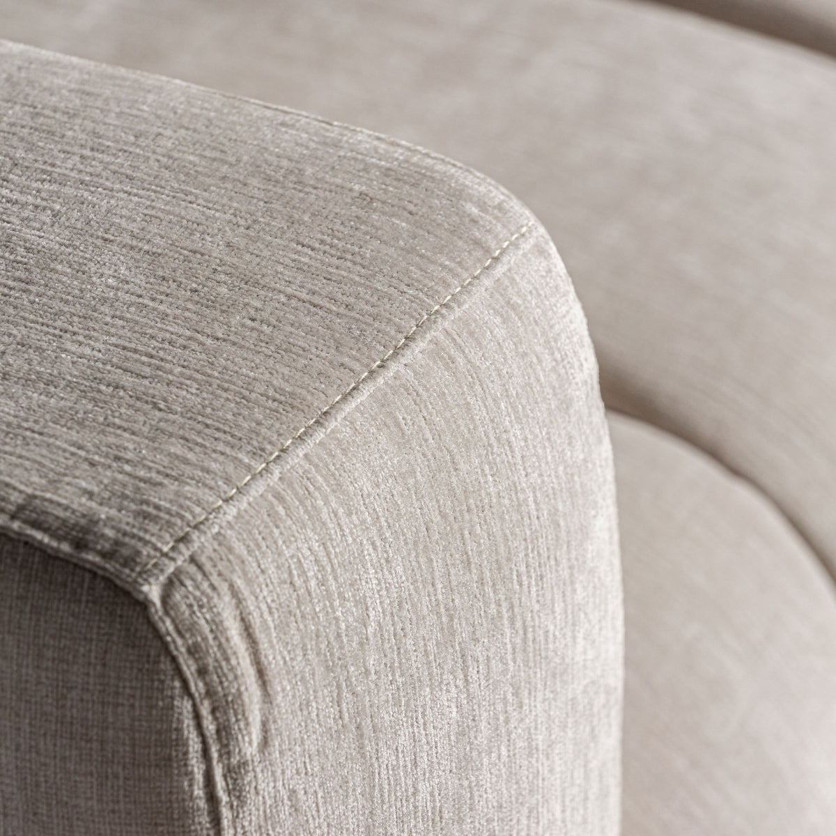 Detalle de la textura del tejido beige en sillón moderno, acabado suave y elegante