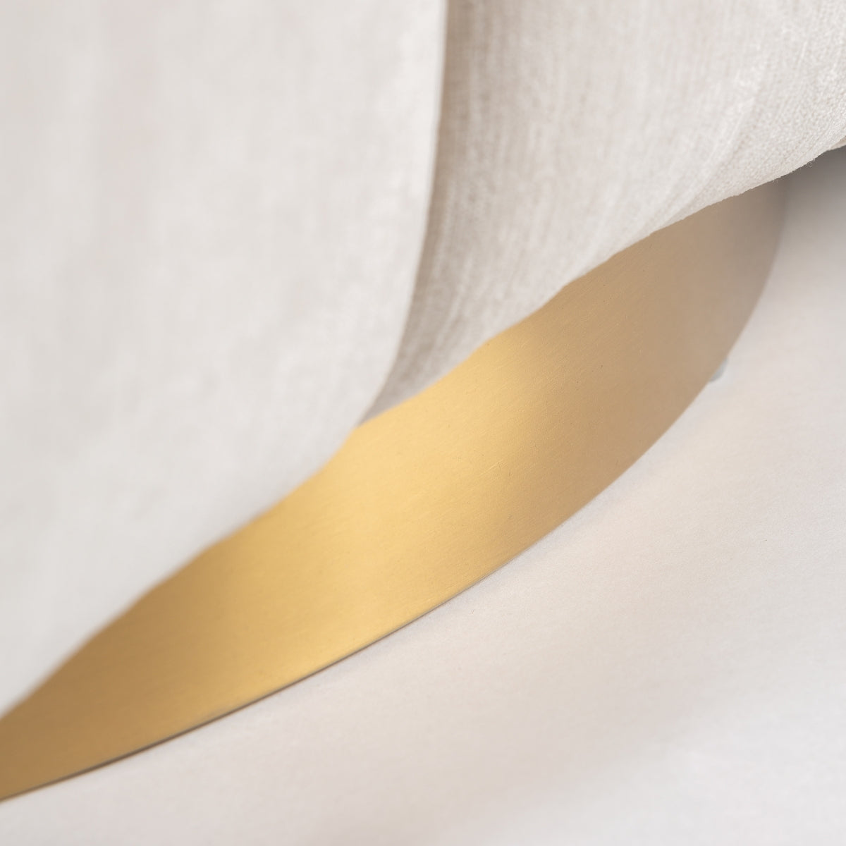 Detalle de la base metálica dorada del sillón giratorio, diseño lujoso y minimalista