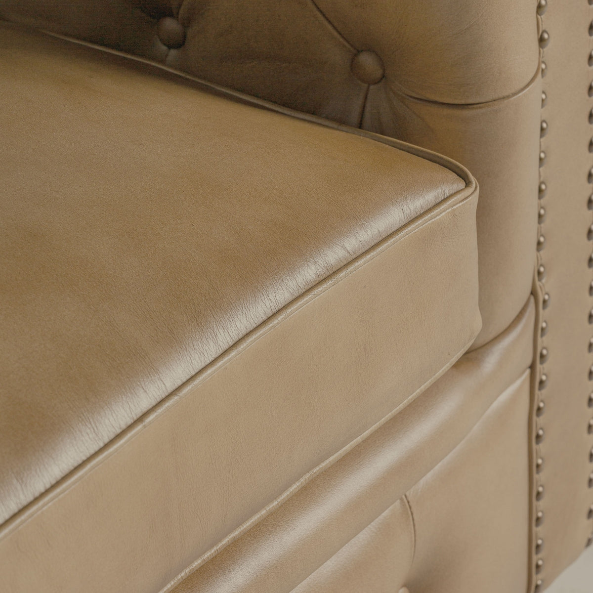 Detalle del cojín de asiento acolchado en piel lisa, costuras finas y tacto suave. Confort y distinción.