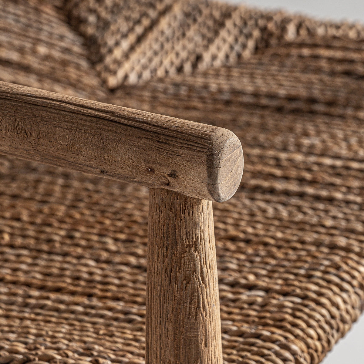 Detalle de brazo redondeado en madera de teka con textura natural y acabado cálido