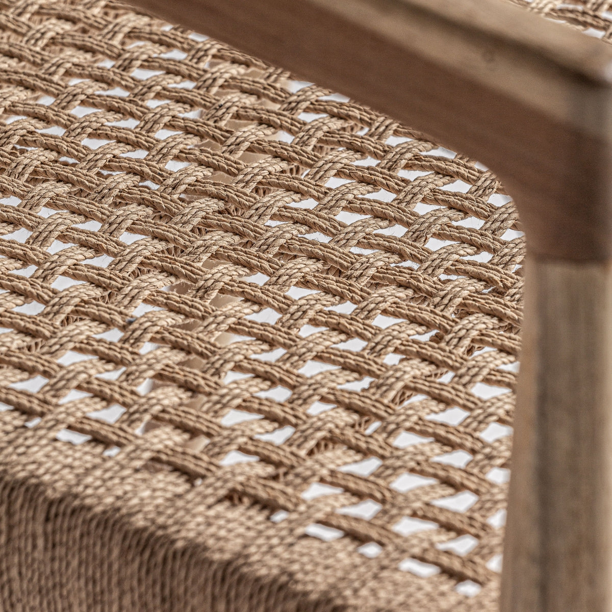 Detalle lateral del asiento trenzado del Sillón Caen con estructura de madera vista, pieza decorativa orgánica boutique_interiorismo-vical