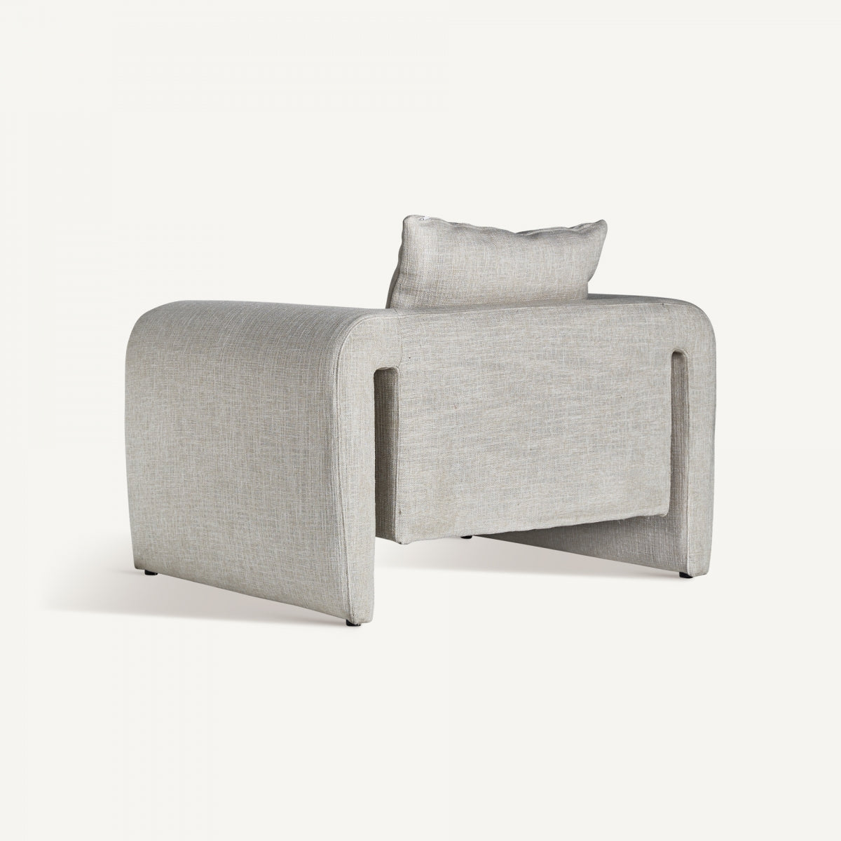 Vista trasera de sillón moderno con respaldo bajo y apertura arquitectónica, acabado textil neutro