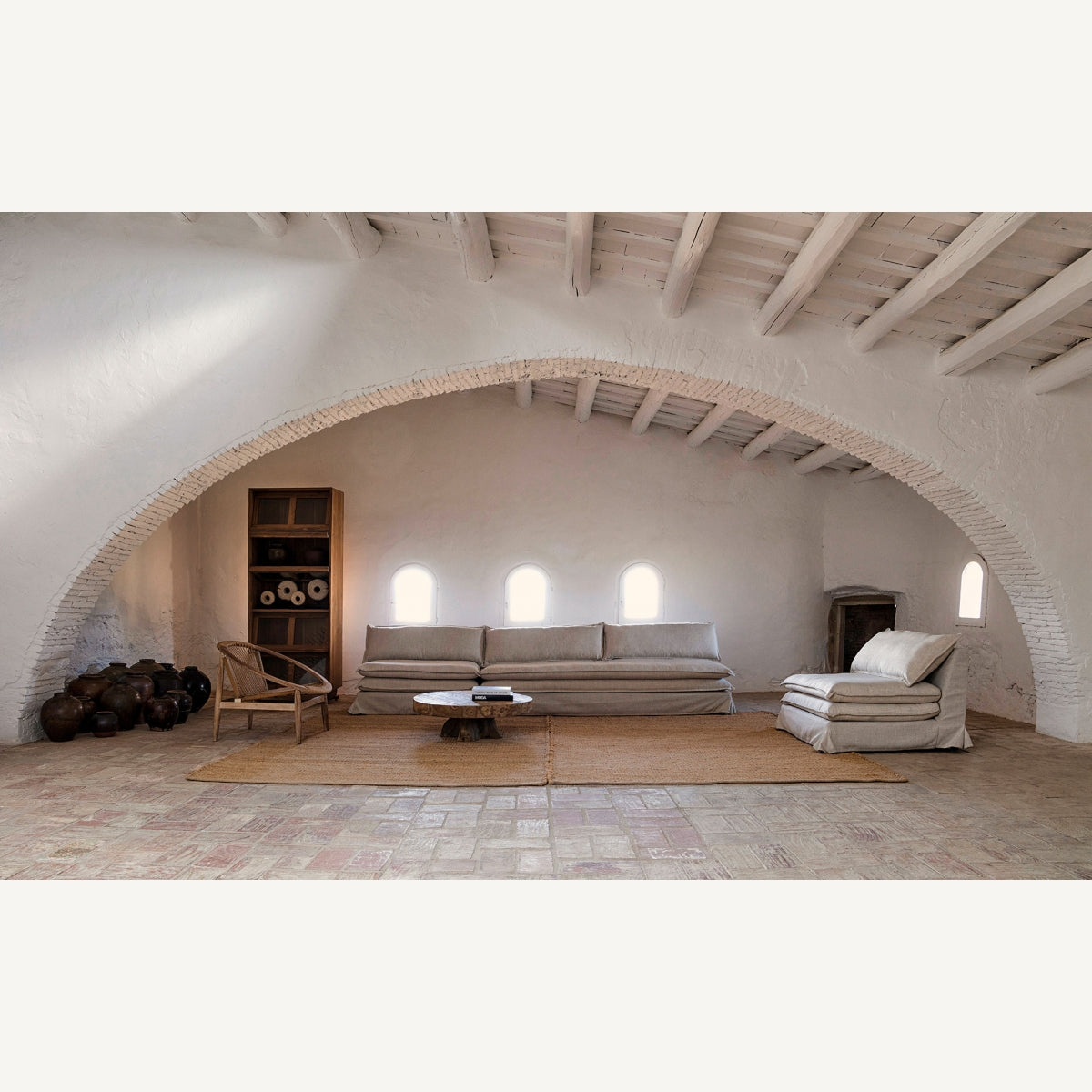 Ambiente rústico con techo abovedado y sofá modular en lino beige estilo mediterráneo