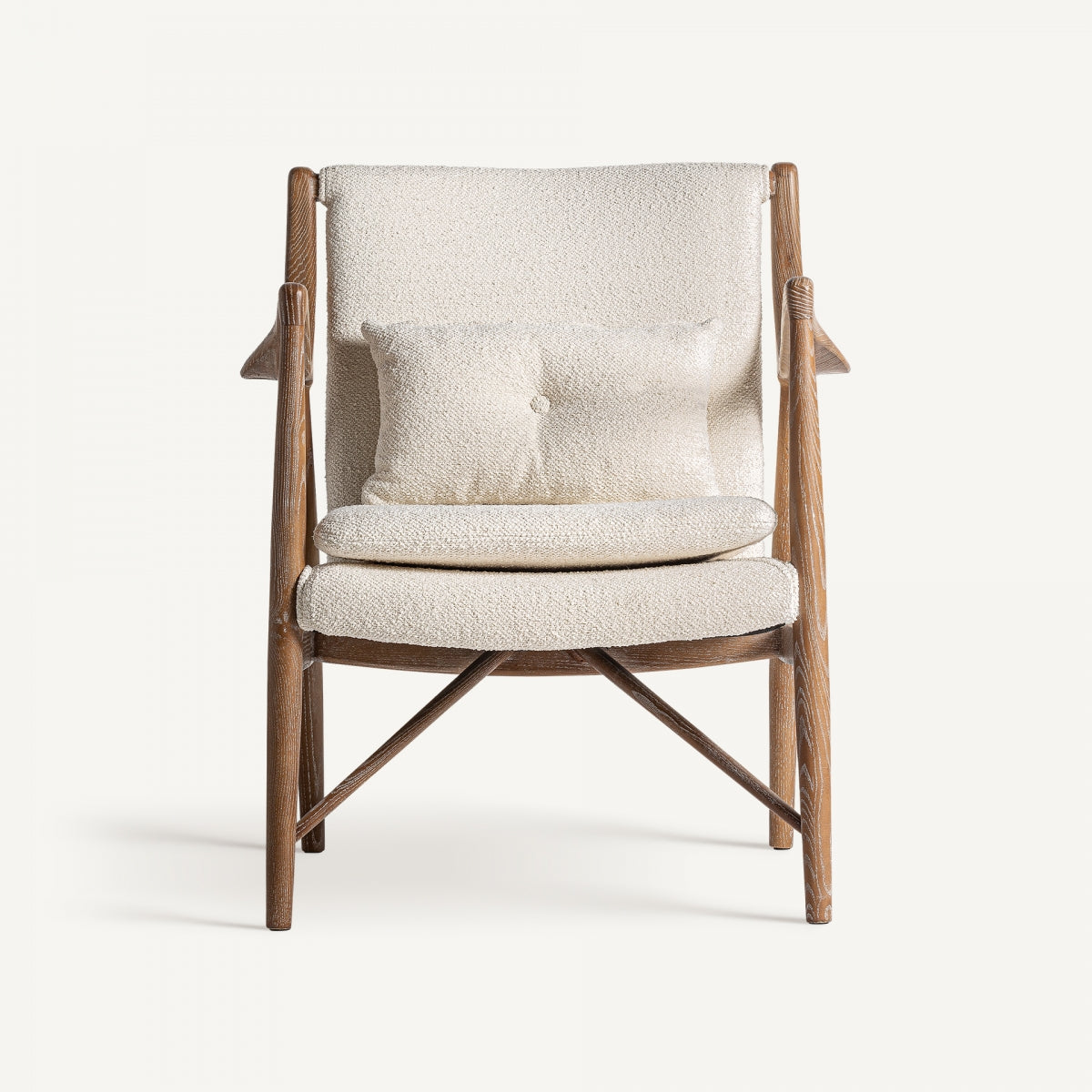 Vista frontal de butaca en tejido bouclé con cojín decorativo, estructura de madera clara