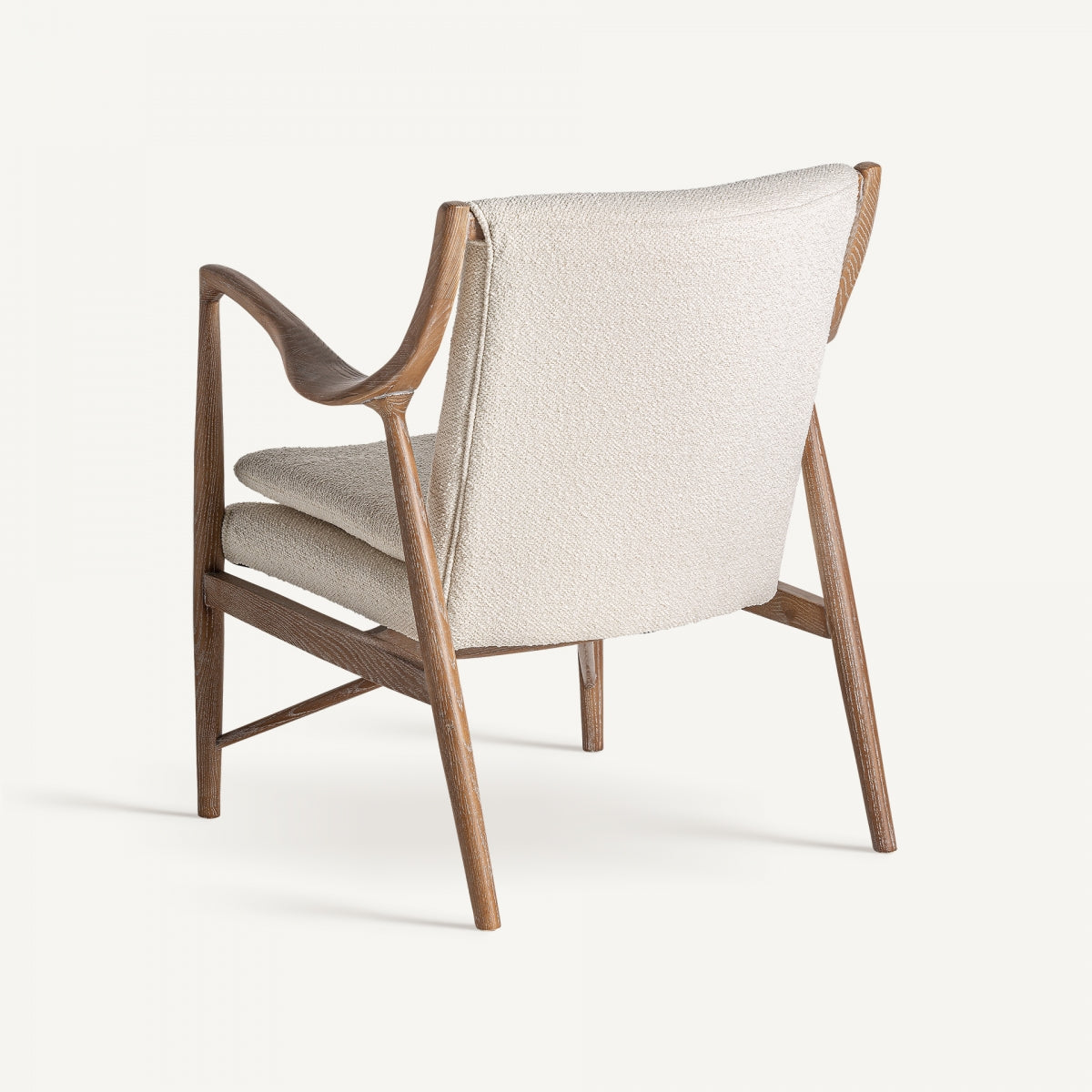 Vista trasera de butaca tapizada en bouclé y patas en madera estilo años 50