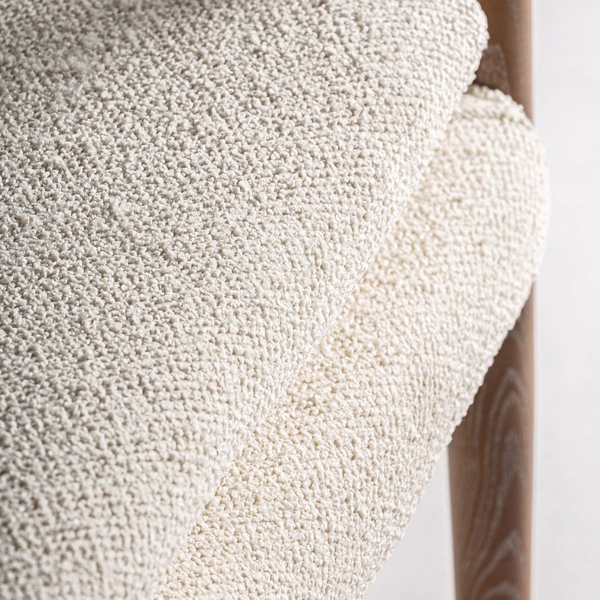 Primer plano del tejido bouclé en tono claro con textura suave y mullida
