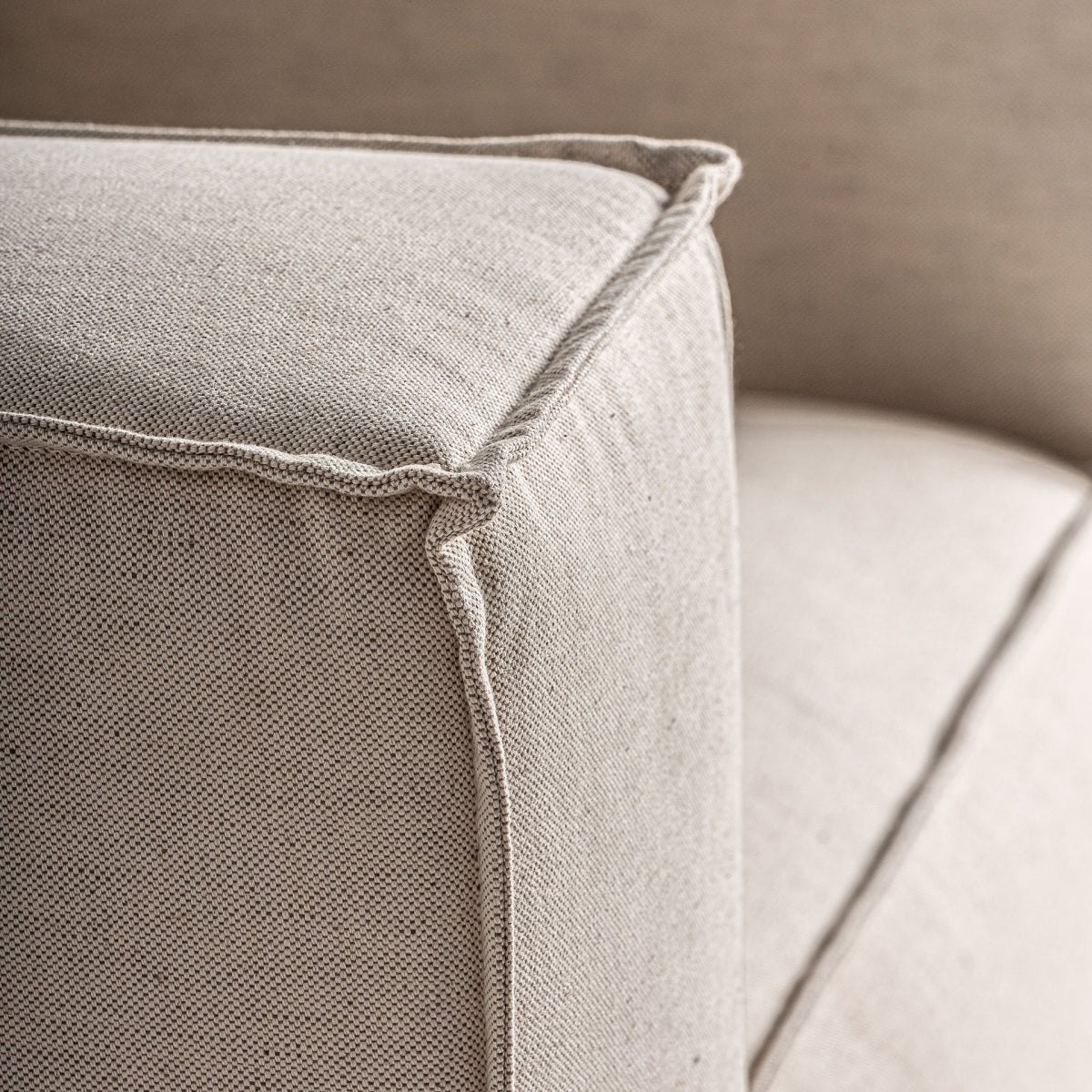 Detalle del tapizado con textura gruesa y costura decorativa del sillón Krakau, acabado natural