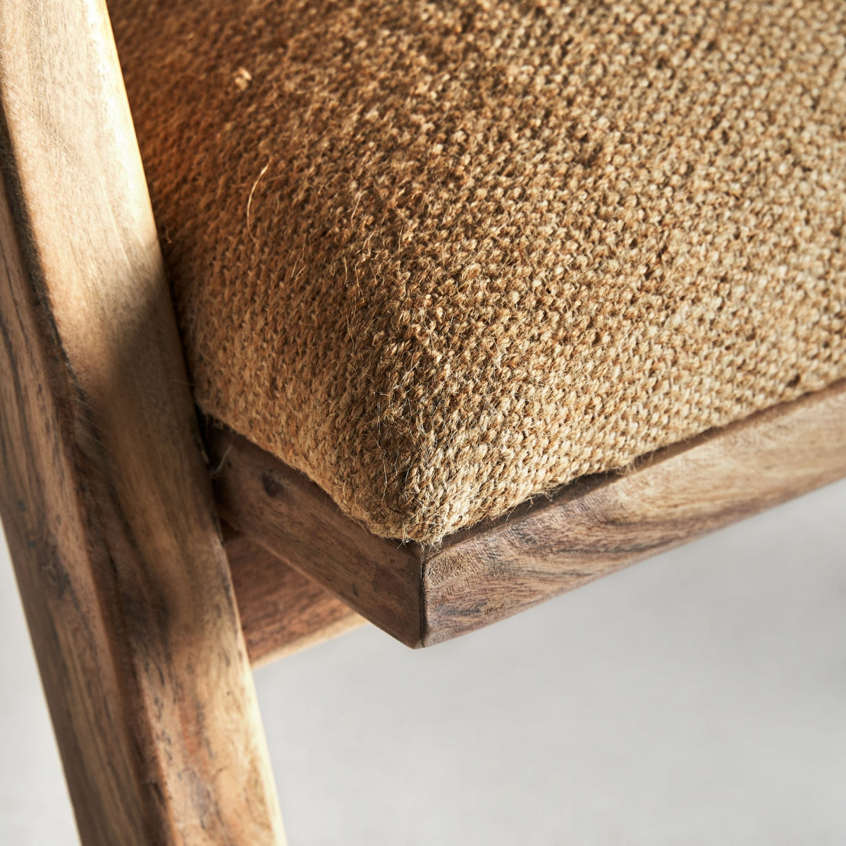 Detalle del asiento tapizado en yute de la butaca Elgin, textura gruesa y cálida.