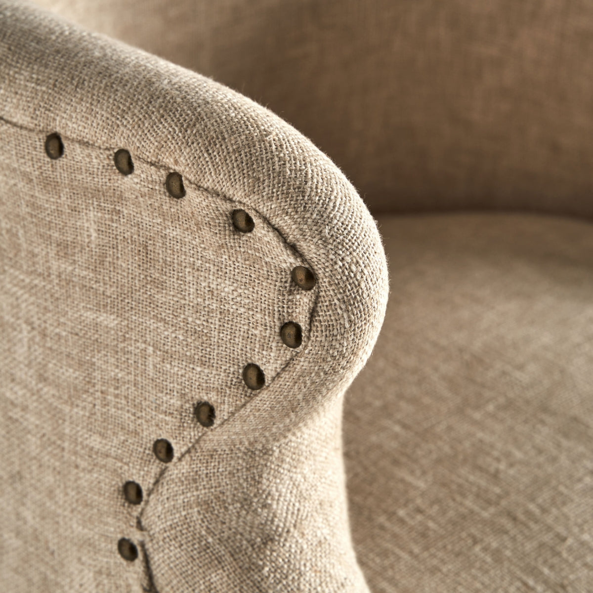 Plano cercano del asiento del sillón Crovie, textura natural y confort visual.