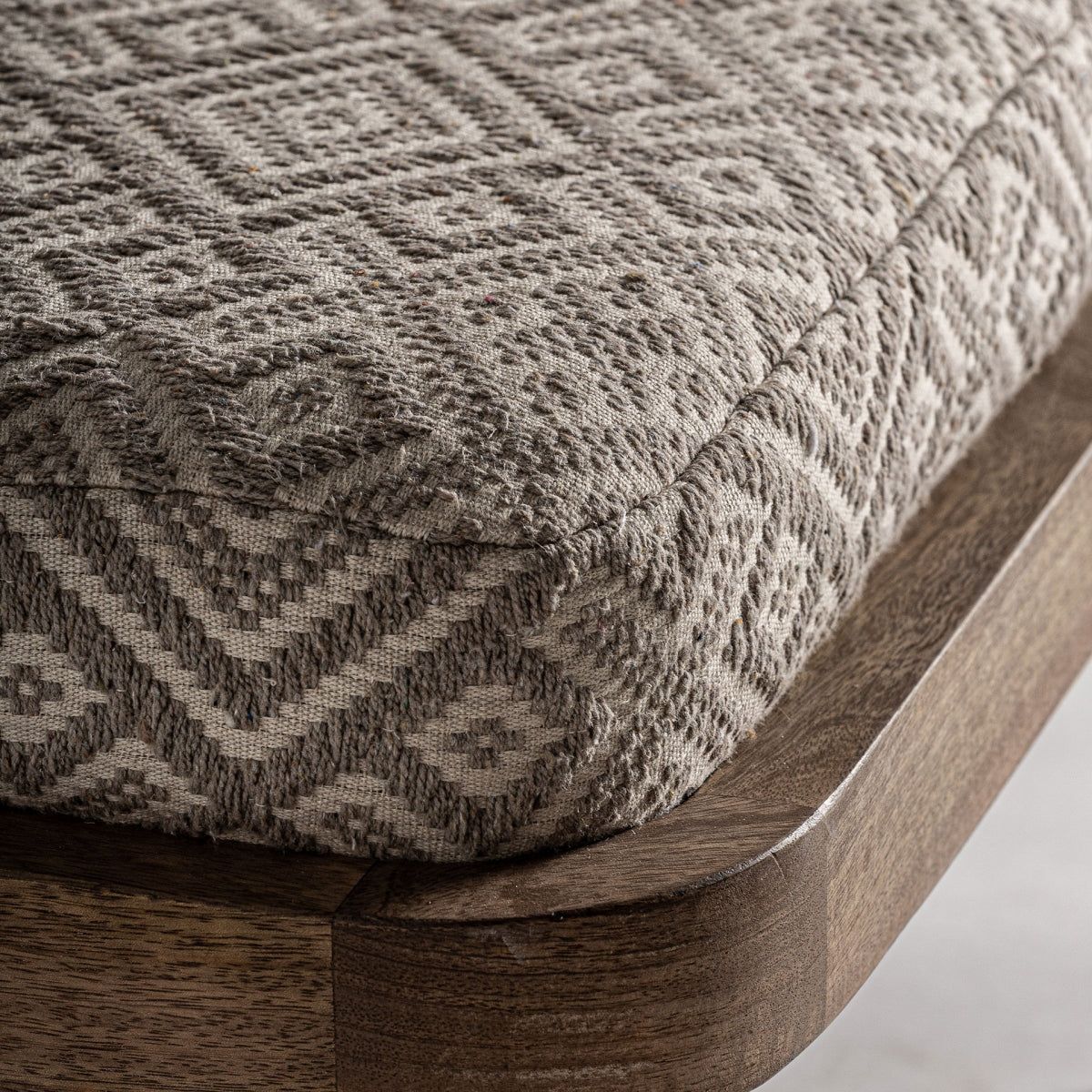 Detalle del asiento con tejido étnico en tonos piedra y estructura redondeada en madera, boutique interiorismo Vical