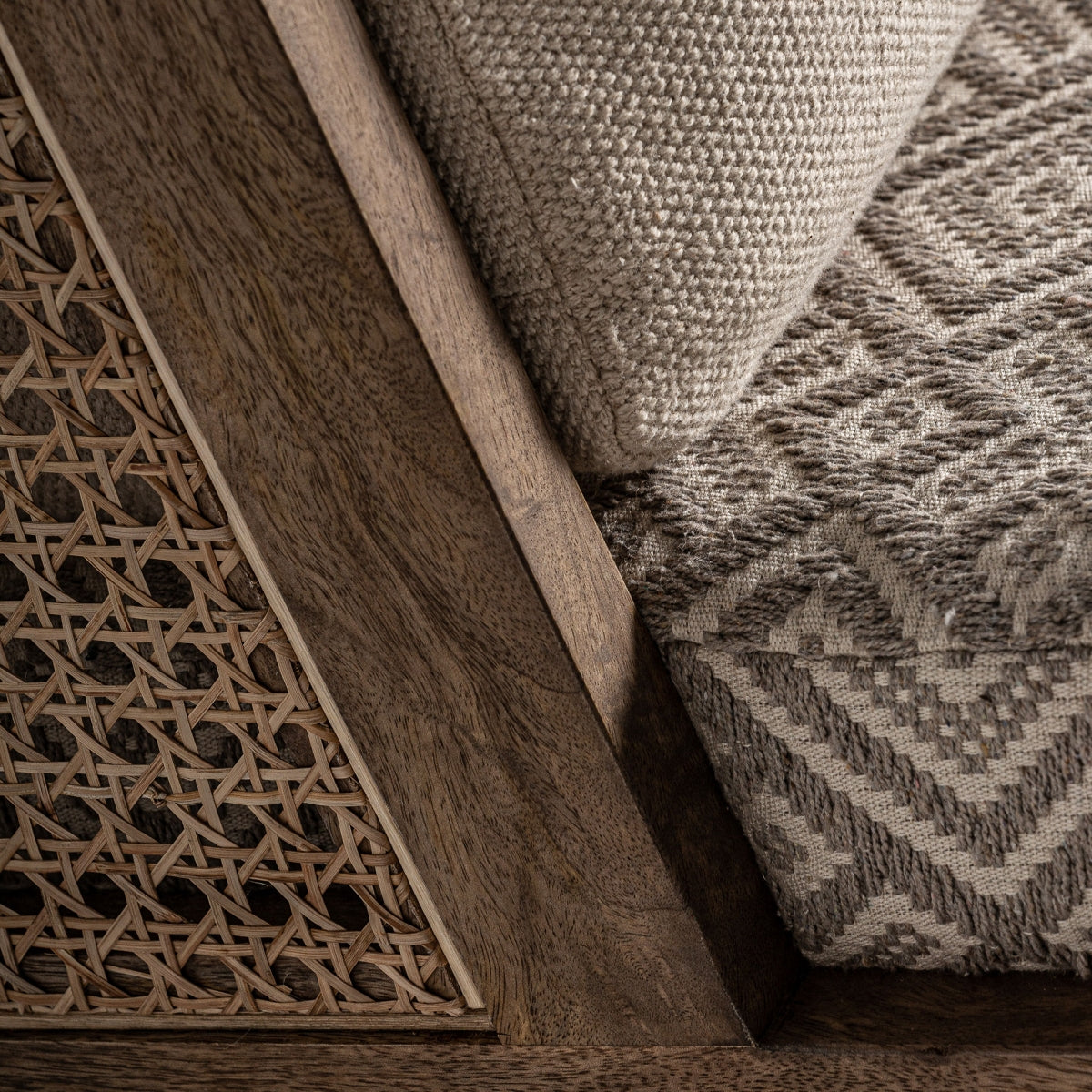 Encuadre del respaldo con cojín beige sobre rejilla artesanal y madera clara, diseño envolvente, boutique interiorismo Vical