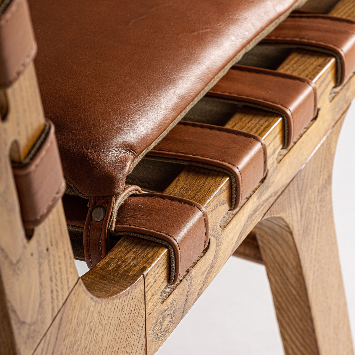 Detalle de uniones en madera natural y cinchas de cuero, estilo bohemio sofisticado