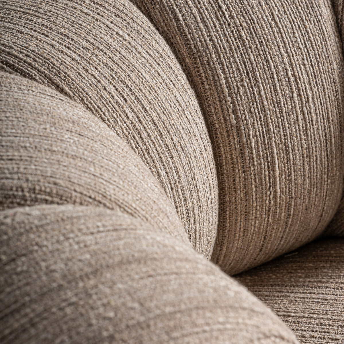 Detalle del respaldo curvo con tapizado texturizado beige en forma de concha, boutique interiorismo vical