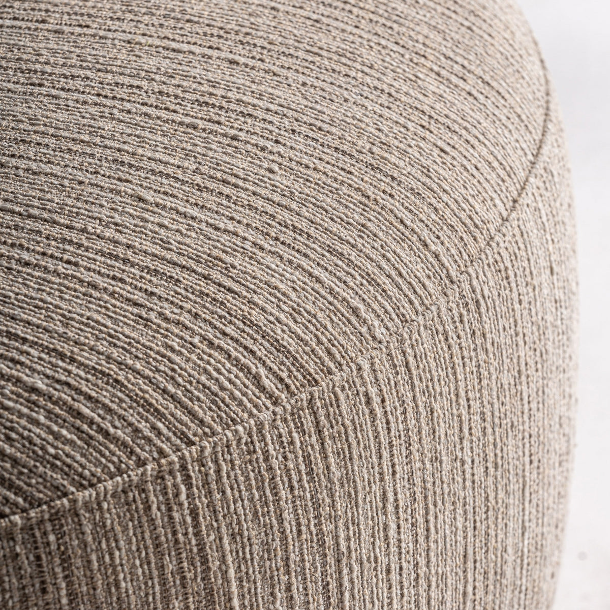 Detalle de la curvatura inferior del asiento del sillón tapizado beige con textura suave, boutique interiorismo vical