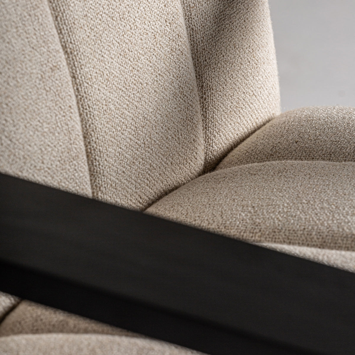 Detalle del tejido bouclé beige del respaldo con textura suave. Estilo acogedor y moderno.