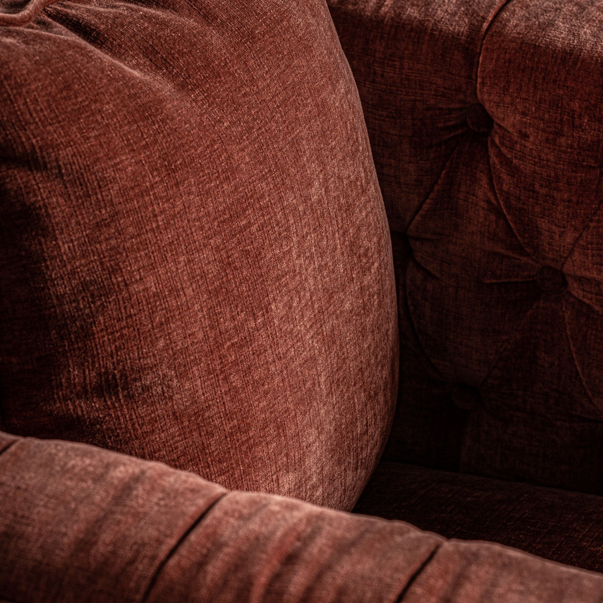 Detalle del cojín y respaldo capitoné en terciopelo color teja | ambiente cálido y elegante