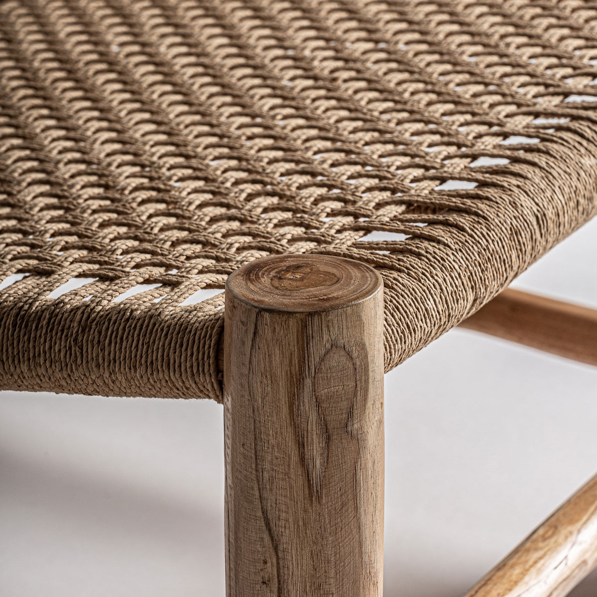 Detalle de la esquina del asiento en cuerda trenzada con pata de madera de teca