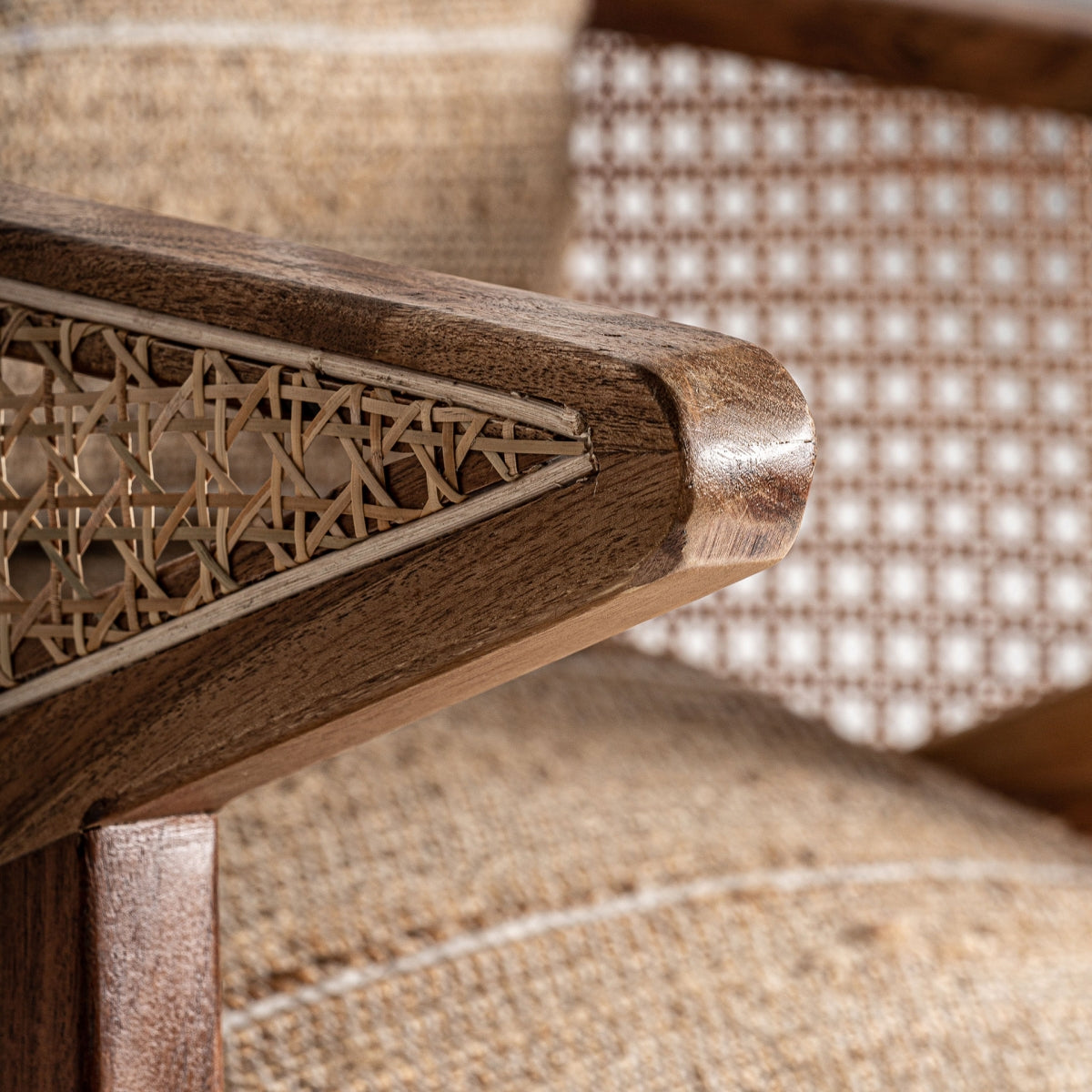 Detalle del apoyabrazos de madera maciza con entramado de ratán artesanal, acabado cálido y textura natural, boutique interiorismo vical