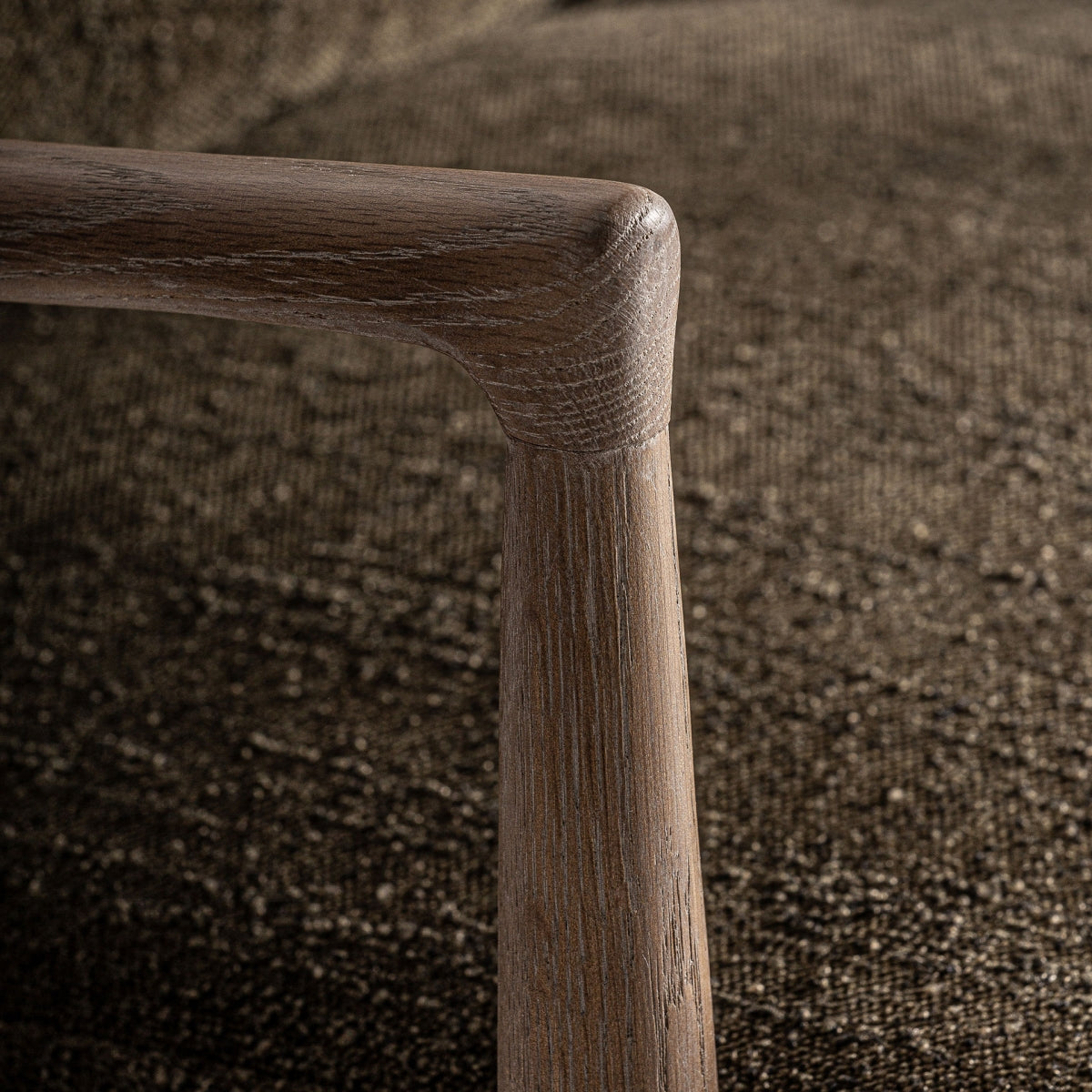 Vista trasera del sillón TARRES, estructura abierta de madera clara con respaldo tapizado envolvente