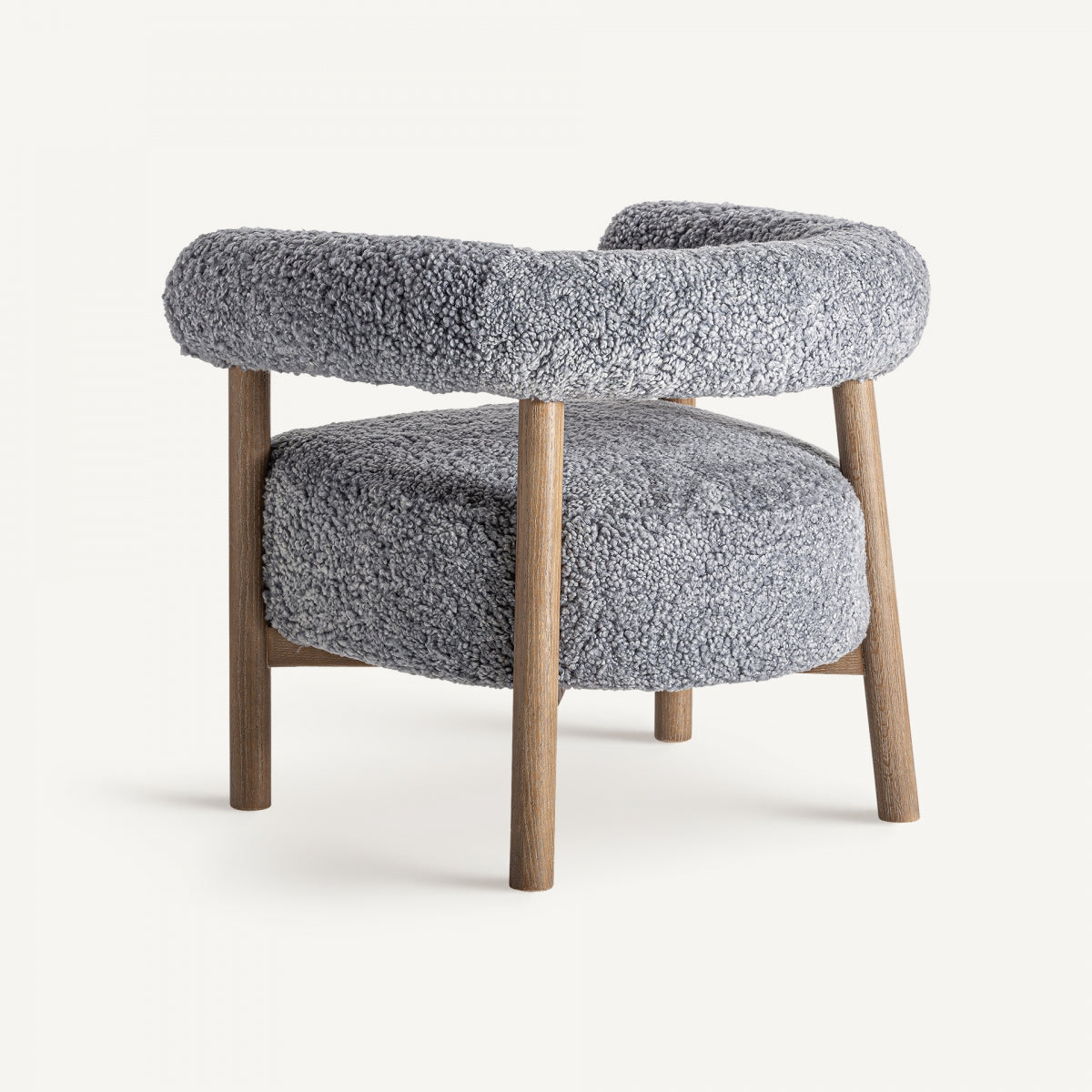 Perspectiva trasera de butaca boucle con respaldo envolvente y estructura de madera cálida.