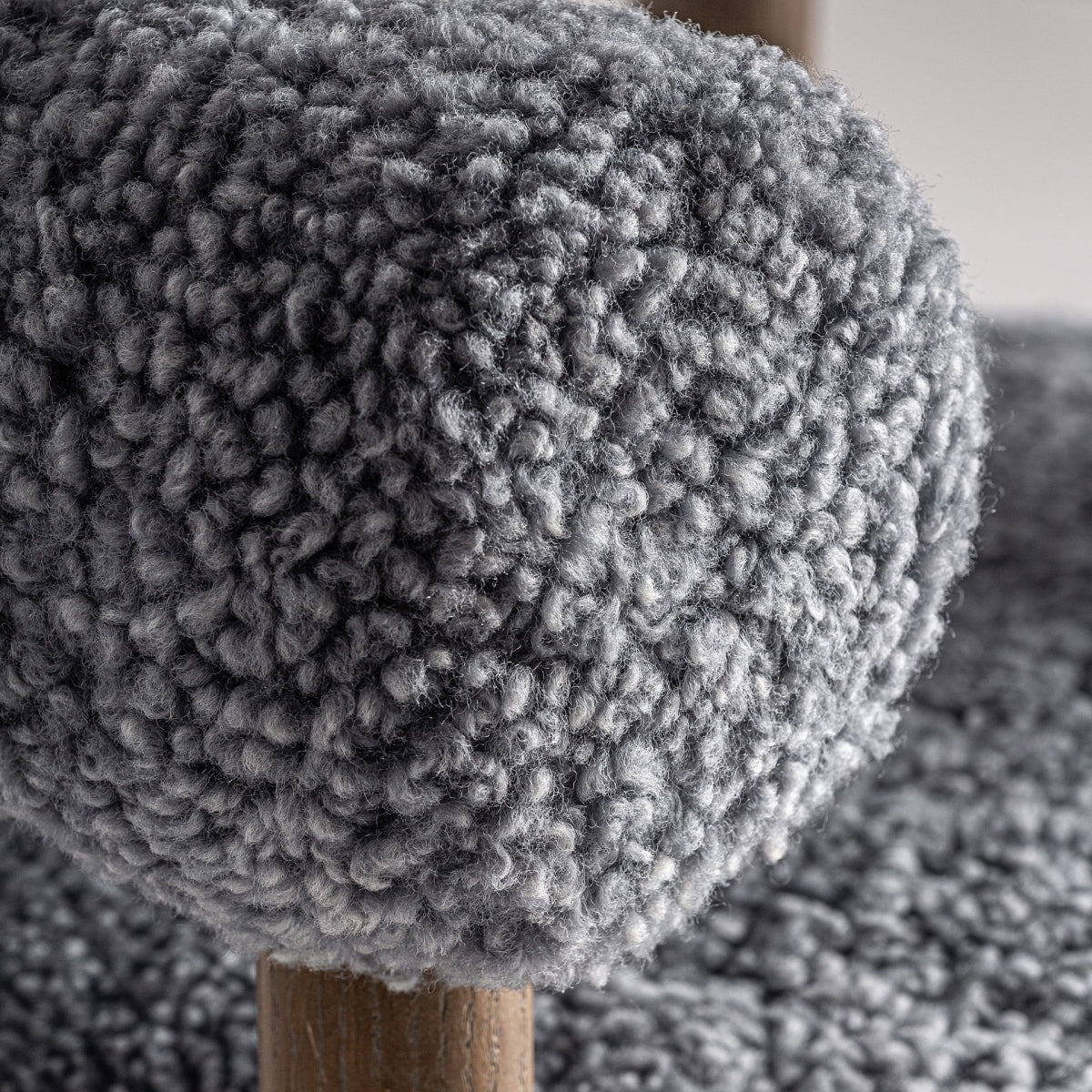 Detalle del tapizado boucle gris con textura rizada y volumen suave.