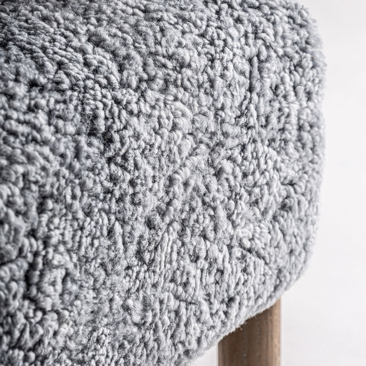 Plano detalle del asiento en boucle gris, textura mullida y acogedora.