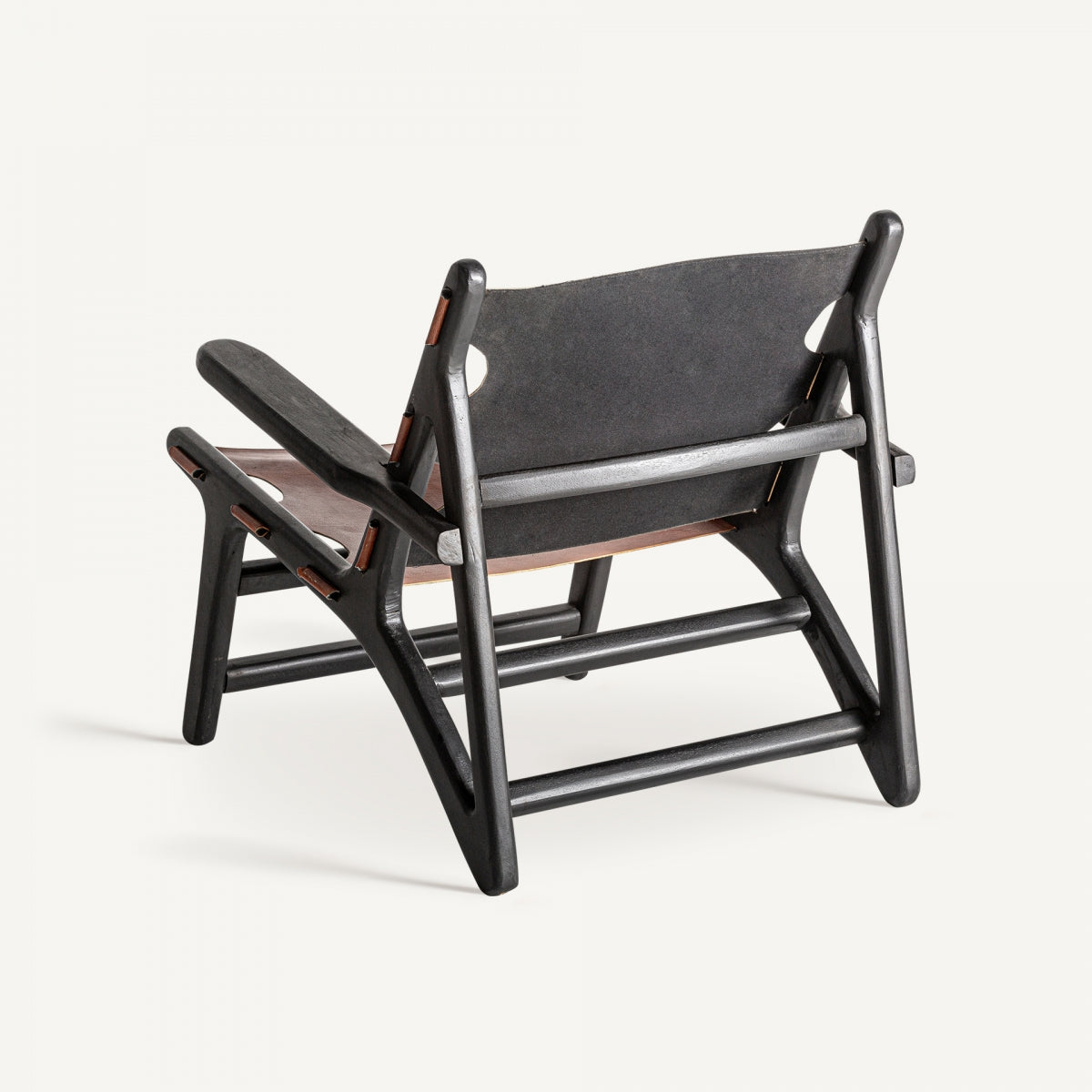 Vista trasera del sillón artesanal en negro y cuero marrón, diseño moderno y escultórico.