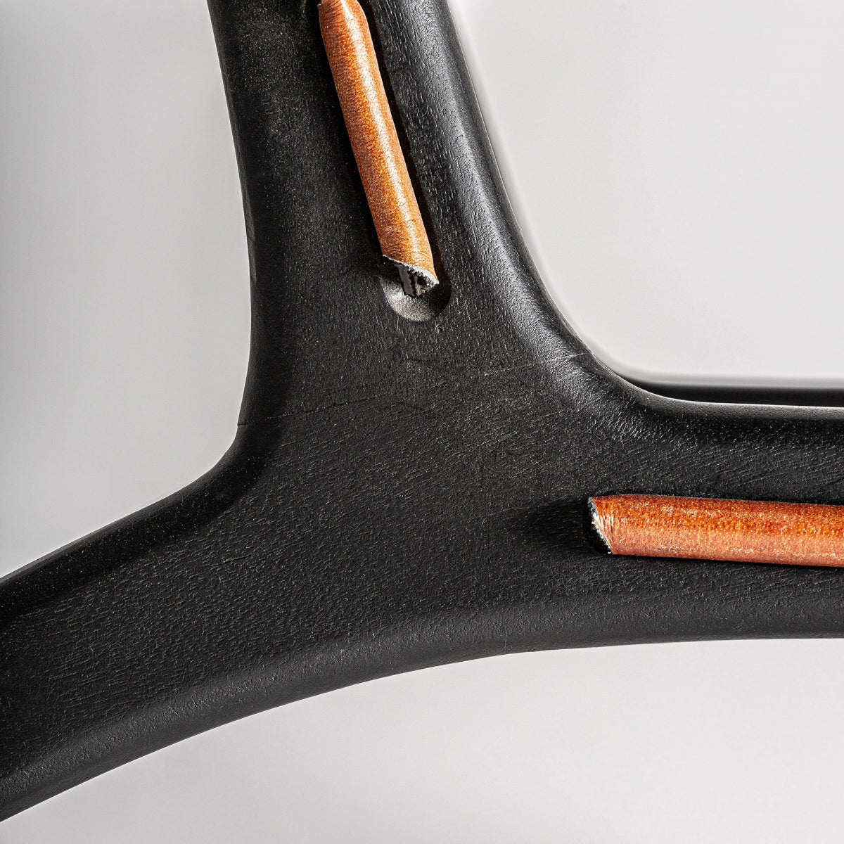 Unión estructural del cuero con la madera negra del sillón, detalle artesanal.