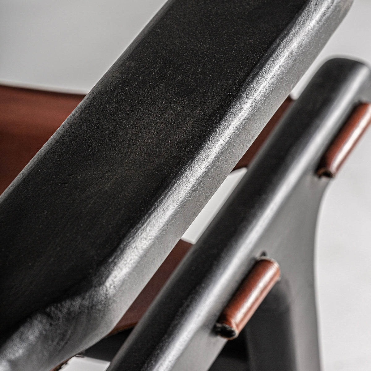 Plano detalle del apoyabrazos del sillón con acabado suave en negro.