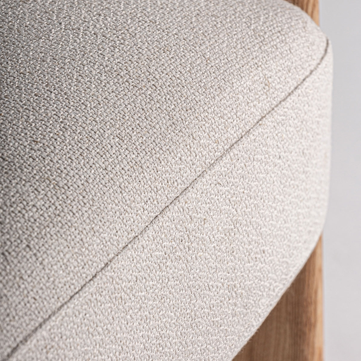 Primer plano del asiento del sillón Nara con tejido bouclé en beige y costuras finas