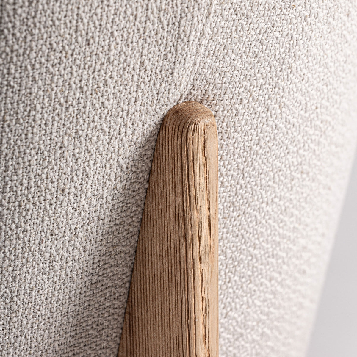 Vista detallada del respaldo del sillón Nara con unión textil y soporte de madera curva